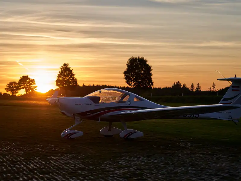 Motorsegler Diamond HK36 Super Dimona am Grasflugplatz im goldenen Abendlicht