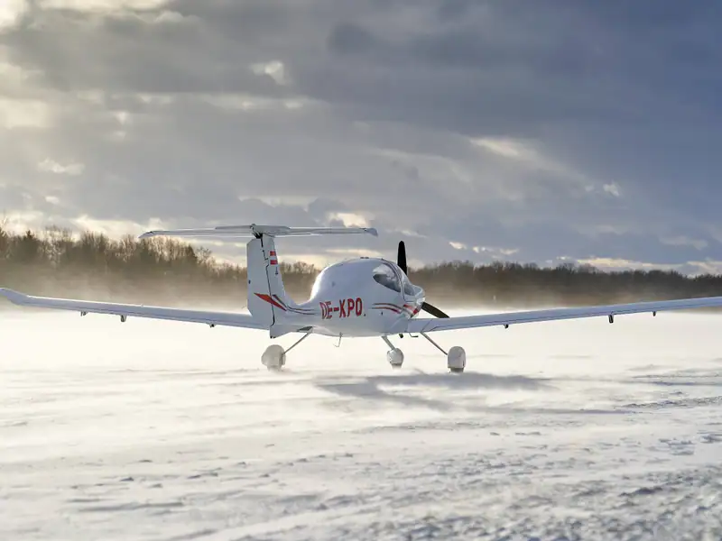 Diamond DA40 mit aufgewirbeltem Schnee auf der winterlichen Piste